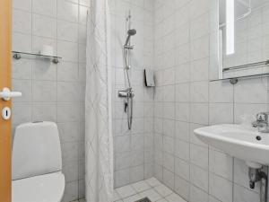 Un baño blanco con ducha y lavabo. en Apartment Bengta - 250m from the sea by Interhome, en Balke