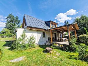 a small white house with a metal roof at Holiday Home Fish & Boat by Interhome in Hurka