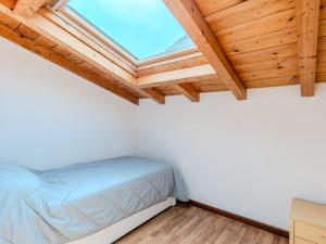 a bedroom with a bed and a skylight at Apartment Borgo Castello-4 by Interhome in Argegno