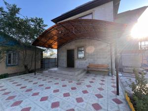 a patio with a bench in front of a building at Aral Guest House in Aralʼsk