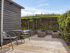a patio with a table and chairs and vines at Holiday Home Arnia - 250m from the sea by Interhome in Hejlsminde