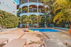 a hotel with a swimming pool with palm trees and a building at Rooftop Terrace Heated Pool Sayulita 2BR in Sayulita