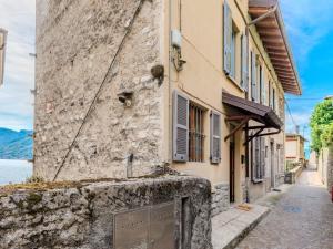 un bâtiment en pierre dans une rue au bord de l'eau dans l'établissement Apartment Martino by Interhome, à Argegno