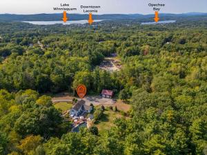 an aerial view of a house in the middle of a forest at Gilford Getaway - Pool & Hot Tub - Lakes Region in Gilford