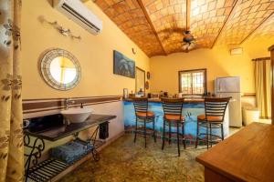 eine Küche mit Bar mit Hockern und Spüle in der Unterkunft Casa Happy Sol - Delfin - Pool Boho Beach Vibes in San Francisco