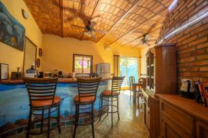 eine Küche mit einer Bar mit Hockern in der Unterkunft Casa Happy Sol - Delfin - Pool Boho Beach Vibes in San Francisco