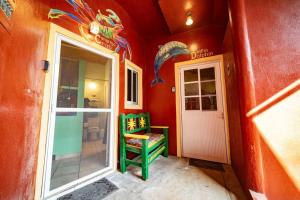 ein rotes Zimmer mit einem grünen Stuhl neben einer Tür in der Unterkunft Casa Happy Sol Cangrejo Pool Surf Relax in San Francisco