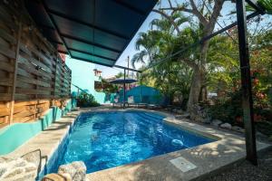 ein Swimmingpool mit Sonnenschirm neben einem Haus in der Unterkunft Casa Happy Sol Atun Balcony Pool Beach Vibes in San Francisco