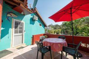 einen Tisch und Stühle mit einem roten Regenschirm auf einer Terrasse in der Unterkunft Casa Happy Sol Atun Balcony Pool Beach Vibes in San Francisco
