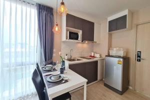 a small kitchen with a table and a refrigerator at Cozy Condo Perfect Location In Nimmanhemin Maya in Chiang Mai