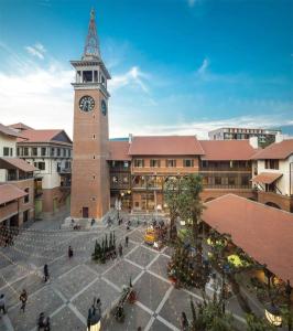 a large building with a clock tower in a city at Cozy Condo Perfect Location In Nimmanhemin Maya in Chiang Mai