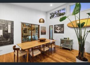 Un comedor con mesa y sillas de madera. en Barnett Bush Retreat, en Torquay