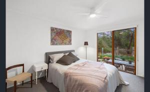 Un dormitorio con una cama y una mesa y una ventana. en Barnett Bush Retreat, en Torquay
