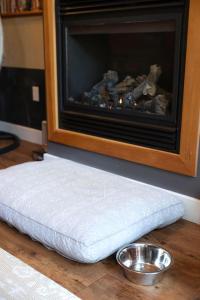 a dog bed sitting on the floor in front of a fireplace at The Inlet Haven - 2 Bedroom on the Inlet in Ucluelet