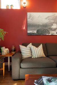 a living room with a couch and a red wall at The Inlet Haven - 2 Bedroom on the Inlet in Ucluelet