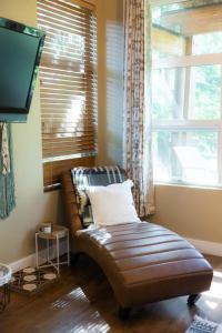 a leather couch sitting in a room with a window at The Inlet Haven - 2 Bedroom on the Inlet in Ucluelet +31 photos