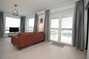 a living room with a couch and large windows at Spacious Apartment for 2 with Sauna in V in Iso-Heikkilä