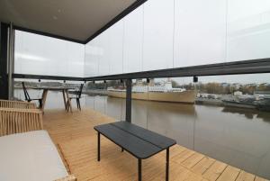 a balcony with a table and a view of a boat at Spacious Apartment for 2 with Sauna in V in Iso-Heikkilä