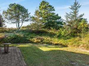 a patio with a table in the grass at Holiday Home Anneka - 750m from the sea by Interhome in Rødhus