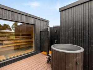 a bathroom with a tub on a deck at Holiday Home Artur - 800m from the sea by Interhome in Fjellerup +16 photos
