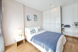Un dormitorio con una cama grande con una manta azul. en Stay Nimman Center with Rooftop Pool, en Chiang Mai 13 fotos más