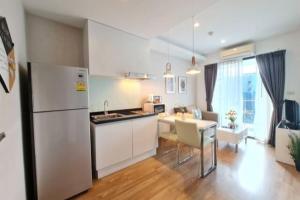 Una cocina con refrigerador y una mesa con sillas. en Stay Nimman Center with Rooftop Pool, en Chiang Mai