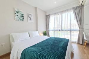 een slaapkamer met een bed en een groot raam bij Lovely 1BR with Rooftop Pool in Nimmanhemin 605 in Chiang Mai +20 foto's