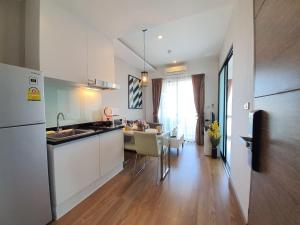 een keuken met een spoelbak en een tafel met stoelen bij Live in Nimman High Floor And Rooftop Pool in Chiang Mai