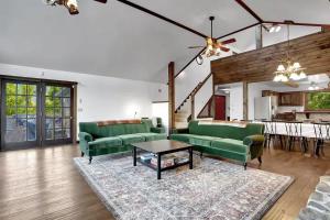 a living room with two green couches and a table at 5 Bedroom Suites Hot Tub Jacuzzi Tub & Game Room in Berkeley Springs