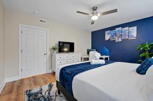 una camera da letto con un letto grande con una parete blu di Upscale King Bed Suite ADA with Free Parking a Lawrenceville