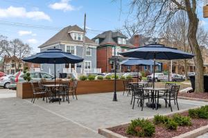 un patio esterno con tavoli, sedie e ombrelloni di Upscale King Bed Suite ADA with Free Parking a Lawrenceville