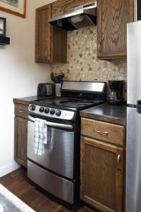 cocina con fogones de acero inoxidable y armarios de madera en Spring Gulch Cabin at Base Camp, en Lawson