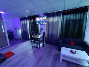 a living room with a couch and a table at CocoonSpa Love Room Jacuzzi Privatif in Toulouse