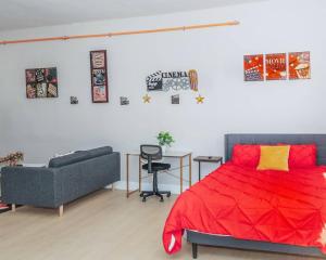 una camera da letto con un letto rosso e un divano di Central Albany Apartment with WiFi Walk to Capitol and Empire Plaza ad Albany