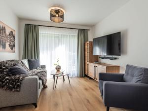 Una sala de estar con un sofá y un televisor. en Apartment Taxacher by Interhome, en Krinberg