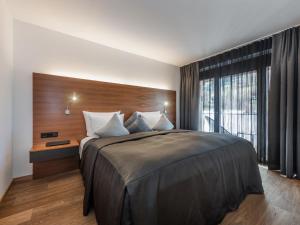 Un dormitorio con una cama grande y una ventana grande. en Apartment Taxacher by Interhome, en Krinberg
