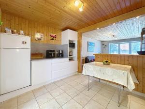 Una cocina con un refrigerador blanco y una mesa. en Holiday Home Les Vents Doux by Interhome, en Tharon-Plage