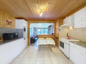 cocina con armarios blancos y techo de madera en Holiday Home Les Vents Doux by Interhome, en Tharon-Plage