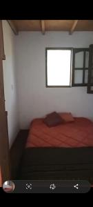 Un dormitorio pequeño con una cama con ventana. en Casa Totem, 