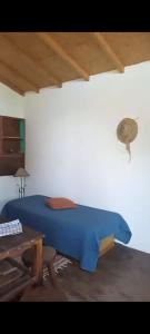 Un dormitorio con una cama azul y una mesa. en Casa Totem,  10 fotos más