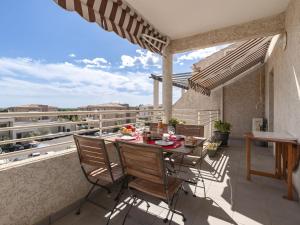a patio with a table and chairs on a balcony at Apartment Albarella by Interhome in LʼArena