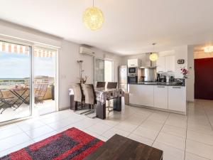 a living room with a table and a kitchen with a view at Apartment Albarella by Interhome in LʼArena