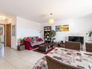 a living room with a red couch and a tv at Apartment Albarella by Interhome in LʼArena +8 photos