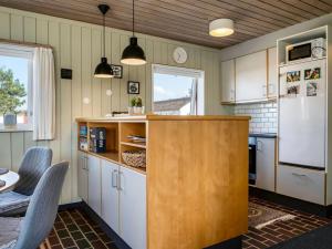 a kitchen with white cabinets and a white refrigerator at Apartment Enwald - 700m from the sea by Interhome in Rødhus +12 photos
