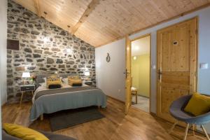 a bedroom with a bed and a stone wall at La Ferme De Mon Grand-père in Saint-Pons