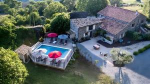 an aerial view of a house with a pool with umbrellas at La Ferme De Mon Grand-père in Saint-Pons