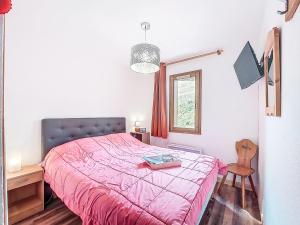 ein Schlafzimmer mit einem rosa Bett, einem Schreibtisch und einem Fenster in der Unterkunft Apartment Les Pistes-21 by Interhome in Le Corbier