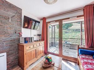 ein Wohnzimmer mit einem TV an einer Backsteinwand in der Unterkunft Apartment Les Pistes-21 by Interhome in Le Corbier