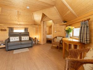 a living room with a couch and a bedroom at Apartment Birch Bothy by Interhome in Coldstone