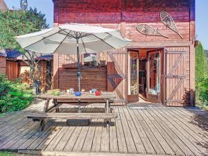 a picnic table with an umbrella on a wooden deck at Holiday Home Les Chalets de La Combe by Interhome in Mémontel +17 photos
